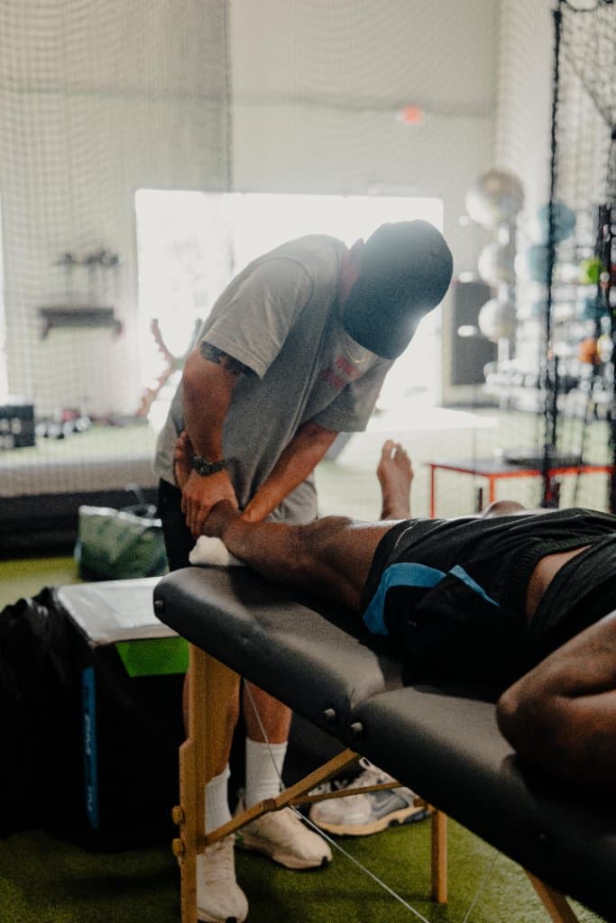 Dr. Alex Chau performing hands-on manual therapy on a client's leg